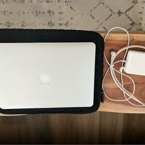 Apple Silver Laptop with Black Quilted Sleeve and White Charger